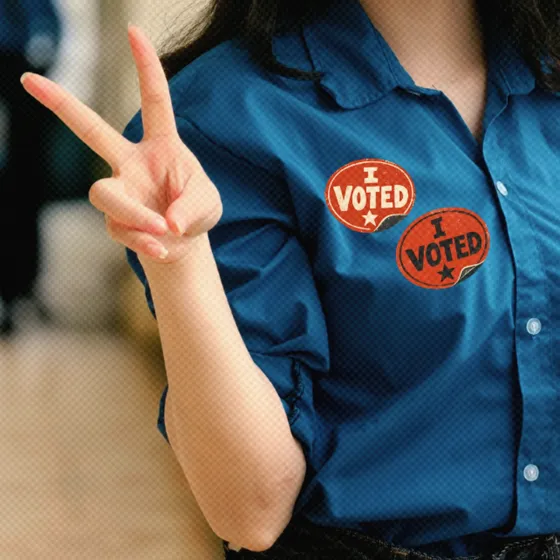 A woman wearing two "I VOTED" stickers holding up a peace sign with her hand.
