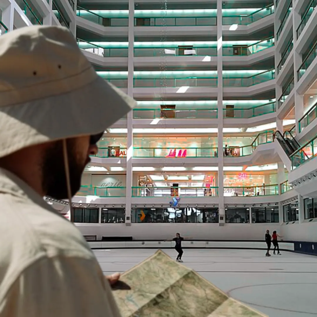 A man in a hat looking at a map inside Dimond Mall.