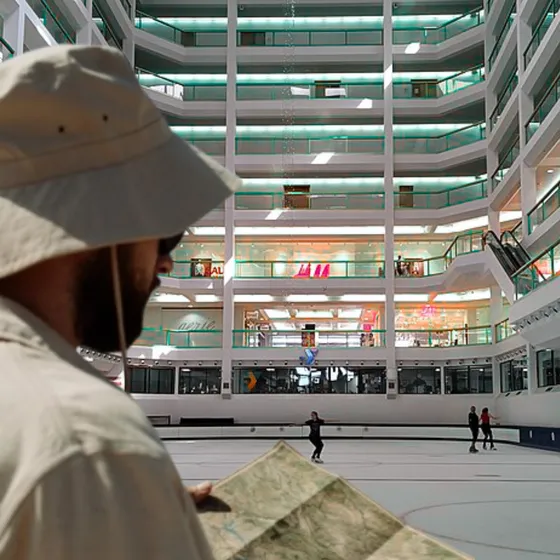 A man in a hat looking at a map inside Dimond Mall.